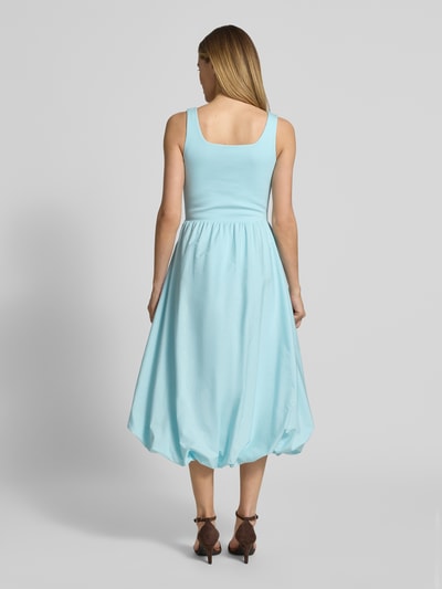 Frauenmodel trägt Knielanges Bubble Kleid mit Karree-Ausschnitt von Rich & Royal in Hellblau, A-Linie, Feinripp, Ganzkörperansicht Rückansicht.