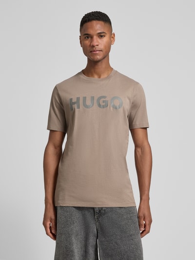 Männermodel trägt Relaxed Fit T-Shirt aus reiner Baumwolle Modell 'DULIVIO' von HUGO in Optik: Unifarben mit Label-Schriftzug, Ganzkörperansicht von vorne.