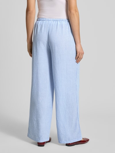 Frauenmodel trägt Pyjama Pants mit elastischem Bund von Review, hellblau gestreift, Loose-Fit, gemütliche Textur, Ganzkörperansicht Rückansicht, Bundweite bei Größe S 41 cm, Innenbeinlänge 77 cm.