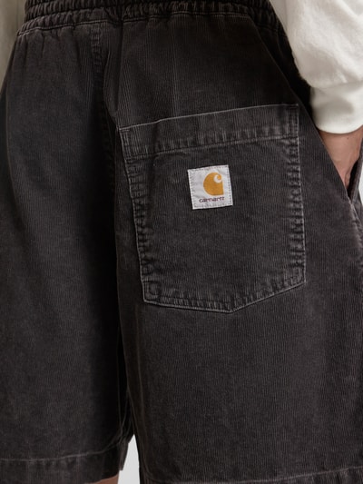 Mężczyznamodel nosi Jeansshorts mit elastischem Bund Modell 'Reynold' od Carhartt Work In Progress, czarny, bawełna, krój relaxed fit, szerokość w rozmiarze M 41 cm, długość nogawki 18 cm, zbliżenie na tył.
