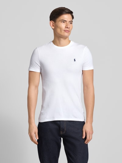 Männermodel trägt weißes T-Shirt mit Label-Stitching von Polo Ralph Lauren aus Baumwolle, Regular Fit, Rundhalsausschnitt, Ganzkörperansicht von vorne.