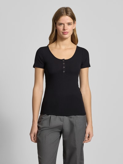 Frauenmodel trägt T-Shirt mit kurzer Druckknopfleiste Modell 'KITTE' von PIECES aus Baumwoll-Elasthan-Mix in Ripp-Optik, Gerader Schnitt, Rundhalsausschnitt, Damen T-Shirt, Ganzkörperansicht von vorne.