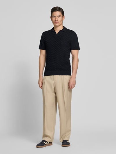 Männermodel trägt Regular Fit Poloshirt mit Strukturmuster Modell 'DYRVIK' von Casual Friday in Dunkelblau, Beige Hose, Ganzkörperansicht von vorne. Poloshirt aus reiner Baumwolle mit Polokragen und gerippten Abschlüssen, Rückenlänge bei Größe M 72 cm.