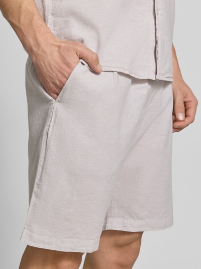 Männermodel trägt Shorts aus Leinen-Baumwoll-Mix mit elastischem Bund von MCNEAL, Regular-Fit, Tunnelzug, Nahaufnahme Oberschenkel.