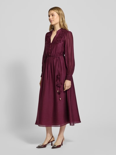 Modelka kobieca nosi wieczorową sukienkę z Lyocell-mix z paskiem 'YASMIN' od Forever New, kolor burgund, kwiatowe aplikacje, widok z przodu całej sylwetki.