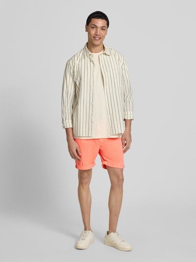 Männermodel trägt Regular Fit Shorts mit Münztasche von Superdry in leuchtendem Orange, Baumwoll-Mix, Herren Shorts, Ganzkörperansicht von vorne.