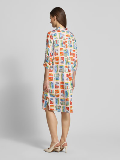 Frauenmodel trägt Knielanges Hemdblusenkleid aus Viskose im Allover-Look von Milano Italy, bunt gemustert, gerader Schnitt, Hemdblusenkragen, 3/4-Arm, Knopfleiste, Rückenlänge 99 cm, Brustweite 55 cm, Ärmellänge 32 cm, Ganzkörperansicht Rückansicht.