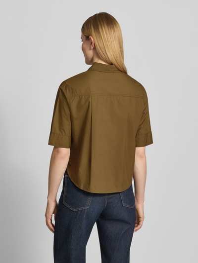 Frauenmodel trägt Boxy Fit Kurzarmbluse aus Baumwoll-Lyocell-Mix von s.Oliver RED LABEL in Khaki, glatte Textur, Ganzkörperansicht Rückansicht.
