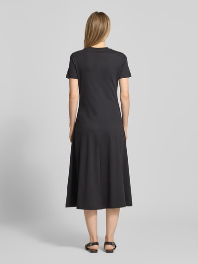 Frauenmodel trägt Midikleid aus reiner Baumwolle von Tommy Hilfiger, unifarben schwarz, Regular Fit, Midi-Länge, Ganzkörperansicht Rückansicht.