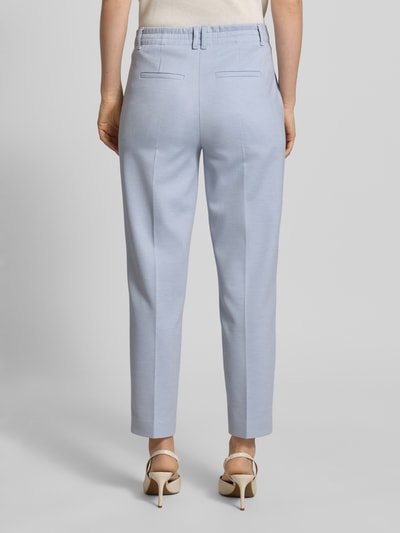 Kobiece model prezentuje Hose mit Bügelfalten und Gesäßtaschen Modell 'SEARCH' od Drykorn, jasnoniebieski materiał-mix z domieszką wiskozy, krój slim fit, widoczne kieszenie z tyłu, całkowity widok od tyłu. Szerokość w rozmiarze 27/34: 68 cm, długość nogawki wewnętrznej: 28 cm.