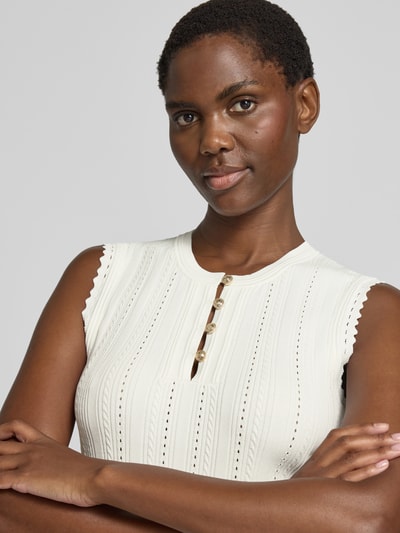 Frauenmodel trägt Stricktop in Pointelle-Strick mit kurzer Knopfleiste von GUESS, weiß, Viskose-Mix, Nahaufnahme Oberkörper.