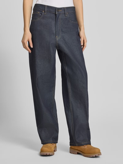 Frauenmodel trägt dunkelblaue Jeans mit weitem Bein Modell 'Brandon' von Carhartt Work In Progress, reine Baumwolle, Eingrifftaschen, Ganzkörperansicht von vorne.