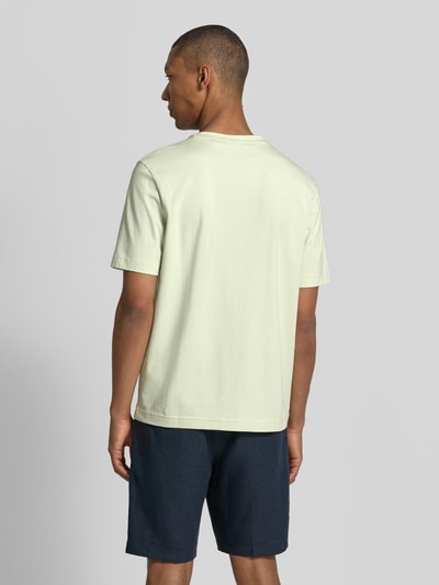 Männermodel trägt ein hellgrünes Regular Fit T-Shirt aus Baumwoll-Mix Modell 'TCHUP' von BOSS für BOSS Orange, Ganzkörperansicht Rückansicht.