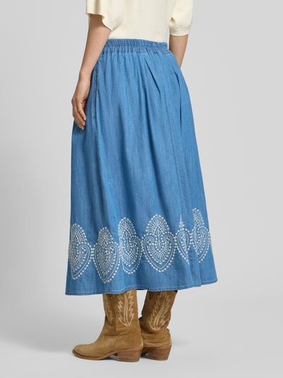 Frauenmodel trägt Midirock in Denim-Optik mit Stitchings von More & More, A-Linie, Baumwoll-Lyocell-Mix, Ganzkörperansicht Rückansicht.