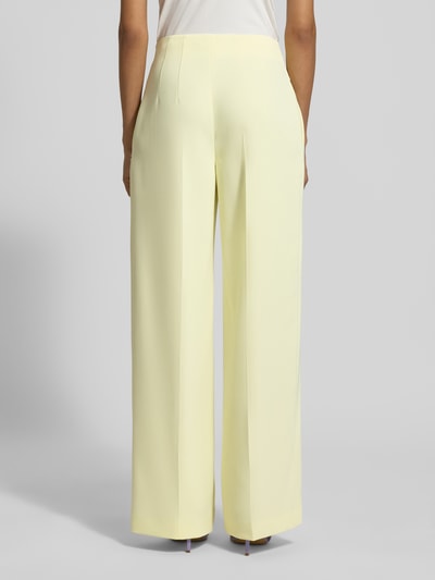 Männermodel trägt Wide Fit Stoffhose mit Bügelfalten von Marc Cain, Mieszanka materiałów z dodatkiem streczu, krój wide fit, wysoki stan, kanty, Szerokość w rozmiarze 36: 40 cm, Długość wewnętrzna nogawki w rozmiarze 36: 81 cm, jasny kolor, tekstura gładka, Ganzkörperansicht Rückansicht.