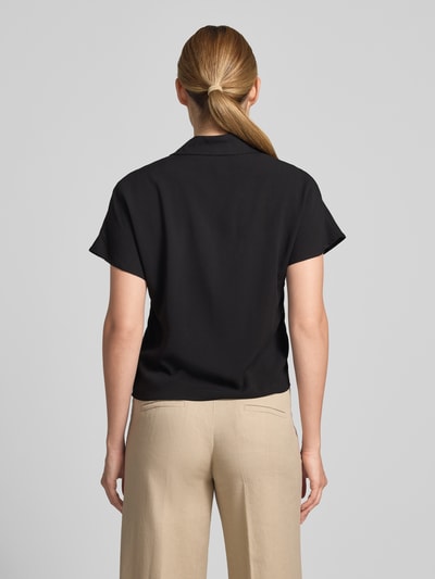 Frauenmodel trägt Regular Fit Bluse aus Viskose mit Knotendetail Modell 'RADIA' von Soyaconcept, schwarze Farbe, Reverskragen, Knopfleiste, Rückenlänge bei Größe S 55 cm, Ärmellänge 10 cm, Ganzkörperansicht Rückansicht.
