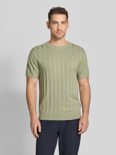 Männermodel trägt Strickshirt aus Viskose-Mix mit Rundhalsausschnitt von Lindbergh in Ripp-Optik, grüner Farbton, Regular-Fit, Ganzkörperansicht von vorne. Rückenlänge bei Größe M: 69 cm, Ärmellänge bei Größe M: 24 cm.