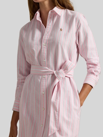 Frauenmodel trägt Regular Fit Oxford-Hemdblusenkleid mit Gürtel von Polo Ralph Lauren, rosa-weiß gestreift mit Logo-Stitching, Nahaufnahme Oberkörper.