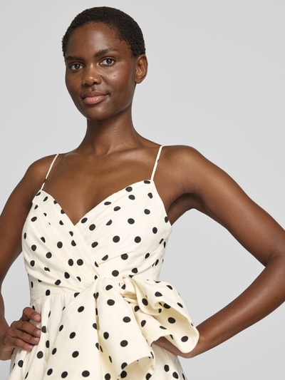 Frauenmodel trägt Cocktailkleid in Wickel-Optik von Forever New mit schwarzen Punkten, Herz-Ausschnitt, Drapierungen, Nahaufnahme Oberkörper.