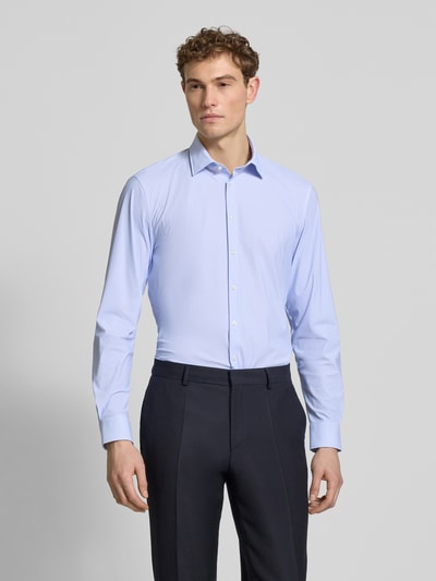 Męski model nosi Slim Fit Business-Hemd mit Kentkragen von Jake*s, jasnoniebieska elastyczna mieszanka materiałów, krój slim fit, kołnierzyk typu kent, listwa guzikowa, długi rękaw, sportowe mankiety, długość tyłu w rozmiarze 39/40: 79 cm, szerokość w rozmiarze 39/40: 45 cm, długość rękawów w rozmiarze 39/40: 67 cm, widok całej sylwetki z przodu.