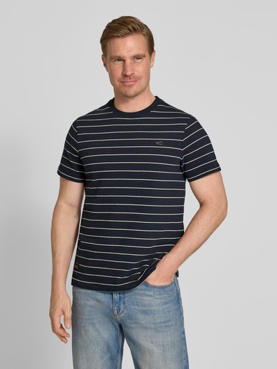 Mannenmodel draagt T-Shirt met Strepenpatroon en Logo van camel active, katoen, regular fit, ronde hals, donkerblauw met witte strepen, voorkant volledig zichtbaar, geheellichaamsaanzicht van voren.