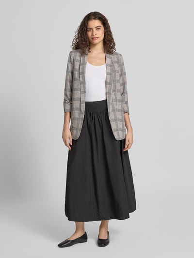 Frauenmodel trägt Shaped Fit Longblazer mit Schalkragen Modell 'BOSELLA' von PIECES in Grau mit Karomuster, Ganzkörperansicht von vorne.