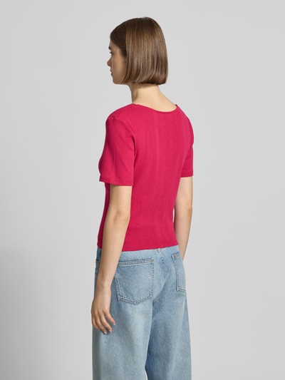 Frauenmodel trägt Blusenshirt in Pointelle-Optik Modell 'Vianne' von OH APRIL in Pink, reine Baumwolle, figurbetont, Ganzkörperansicht Rückansicht.