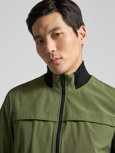 Männermodel trägt kurtka Peuterey Jacke mit Stehkragen Modell 'POTOSI', mieszanka materiałów z dodatkiem streczu, krój regular fit, oliwkowy z czarnym detalem, zamek błyskawiczny dwustronny, szerokość ramion w rozmiarze M 49 cm, szerokość klatki piersiowej w rozmiarze M 59 cm, długość tyłu w rozmiarze M 64 cm, długość rękawów w rozmiarze M 67 cm, Nahaufnahme górnej części ciała z przodu