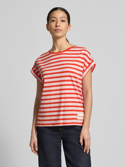 Frauenmodel trägt Oversized T-Shirt mit Label-Detail von Smith and Soul, rot-weiß gestreift, Lyocell-Baumwoll-Mix, Rundhalsausschnitt, Rückenlänge 60 cm in Größe S, Ganzkörperansicht von vorne.