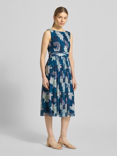 Frauenmodel trägt Cocktailkleid mit Taillenband von Christian Berg Cocktail in Blau mit floralem Muster, Elastischer-Material-Mix, Tailliert, Midikleid, Rundhalsausschnitt, Raffungen, Reißverschluss Rückseite, Ganzkörperansicht von vorne.