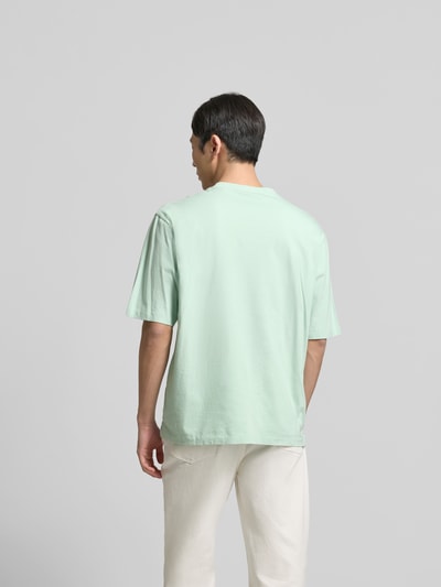 Männermodel trägt Loose Fit T-Shirt mit Logo-Stitching von Dsquared2 in Mintgrün, reine Baumwolle, Ganzkörperansicht Rückansicht.