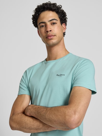 Mężczyzna model nosi Slim Fit T-Shirt aus Baumwoll-Mix Modell 'ORIGINAL BASIC 3N' od Pepe Jeans, kolor jednolity, krótkie rękawy, dekolt okrągły, jersey, etykieta z nadrukiem, ujęcie z przodu górnej części ciała