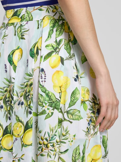 Frauenmodel trägt Midirock im Allover-Look von Marc Cain aus Reine Baumwolle mit A-Linie, lebendige Gelb-Grün-Töne, Nahaufnahme Oberkörper.