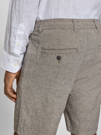 Männermodel trägt Regular Fit Chinoshorts aus Baumwoll-Leinen-Mix Modell 'BRODY' von SELECTED HOMME in Beige, Detailaufnahme Rückansicht. Unifarbene Optik, Flammgarnstruktur, Gesäßtasche mit Knopf, Gürtelschlaufen und Tunnelzug, hochwertiger Materialmix.