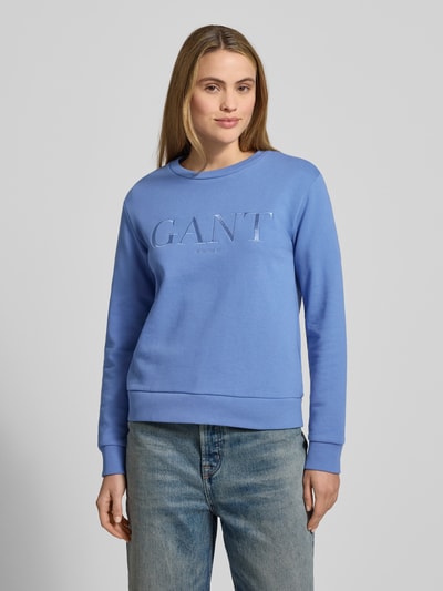 Frauenmodel trägt Sweatshirt mit Label-Stitching und Rundhalsausschnitt von Gant in Blau, reine Baumwolle, Regular Fit, Ganzkörperansicht von vorne.