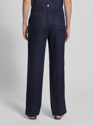 Kobiece model prezentuje Leinenhose mit elastischem Bund und Gesäßtaschen od Christian Berg Woman, ciemnogranatowy len, krój regular fit, elastyczny pas, tylne kieszenie, szerokość w rozmiarze 36: 40 cm, długość wewnętrzna nogawki w rozmiarze 36: 77 cm, pełny widok sylwetki z tyłu.