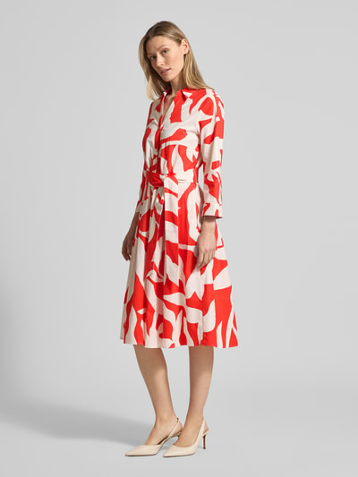 Frauenmodel trägt Midikleid mit Taillenband von More & More, rot-weiß gemustert, Baumwoll-Elasthan-Mix, taillierte Passform, Ganzkörperansicht von vorne.