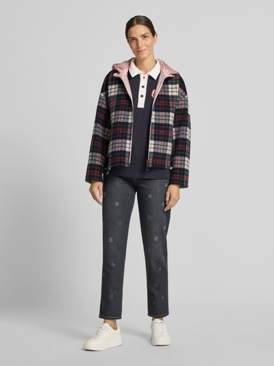 Frauenmodel trägt Regular Fit Jacke mit Kapuze von Marc Cain, mehrfarbig kariert, Zweiwege-Reißverschluss, Ganzkörperansicht von vorne. Rückenlänge, Schulterbreite, Brustweite sowie Ärmellänge entsprechen Größe 36.
