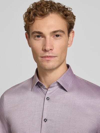 Męski model nosi Super Slim Fit Businesshemd aus Baumwoll-Mix von OLYMP No. Six, delikatny fiolet, subtelna faktura, zbliżenie na górną część ciała.