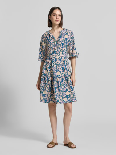 Frauenmodel trägt Knielanges Kleid aus Viskose im Allover-Look von Christian Berg Woman mit A-Linie, V-Ausschnitt, Volants, Bindegürtel, Ganzkörperansicht von vorne.