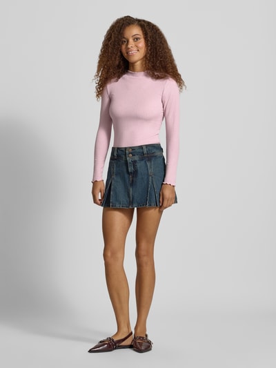Kobiece modelka nosi różową, prążkowaną bluzkę z długim rękawem Slim Fit Langarmshirt mit Viskose-Anteil Modell 'EMMA' od ONLY, widok całej sylwetki z przodu.