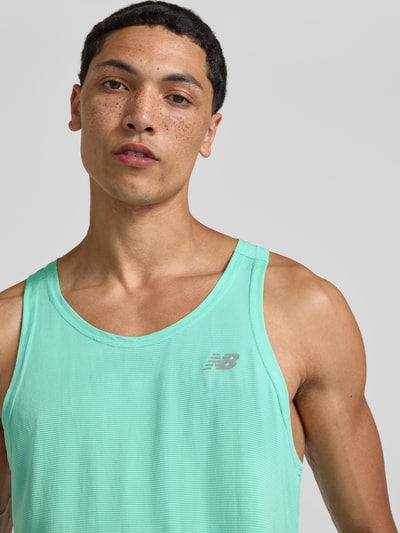 Männermodel trägt Tanktop mit Logo und Rundhalsausschnitt von New Balance in Regular-Fit, Rückenlänge bei Größe M 66 cm, Nahaufnahme Oberkörper.