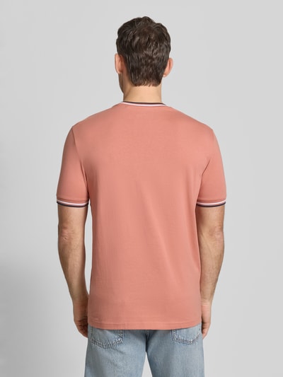 Mężczyzna model nosi T-Shirt mit Kontraststreifen und Rundhalsausschnitt von Christian Berg Men, bawełna z domieszką elastanu, krój regular fit, kontrastowe paski, okrągły dekolt, długość tyłu w rozmiarze M: 71 cm, widok całej sylwetki od tyłu.