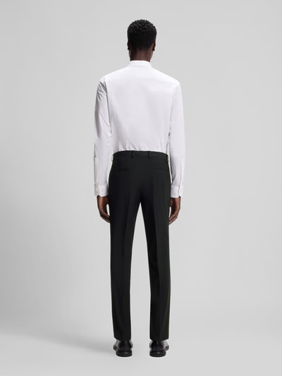 Männermodel trägt Slim Fit Anzughose aus Woll-Mix Modell 'HESTEN' von HUGO, uni melange, met bandplooi, zij- en achterzakken, achteraanzicht gehele lichaam.