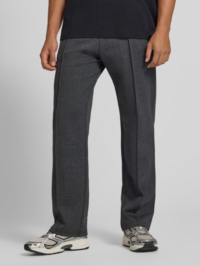 Męski model nosi Straight Fit Sweatpants mit elastischem Bund von REVIEW, Mieszanka materiałów z mieszanką bawełny, kanty, ciemnoszary kolor, Szerokość w rozmiarze M: 42 cm, Długość wewnętrzna nogawki: 82 cm, Ganzkörperansicht z przodu.