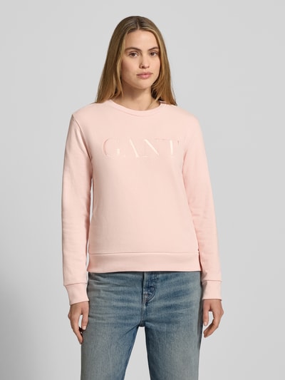 Frauenmodel trägt Sweatshirt mit Label-Stitching und Rundhalsausschnitt von Gant, hellrosa, reine Baumwolle, Regular Fit, Ganzkörperansicht von vorne.