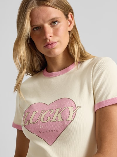 Frauenmodel trägt T-Shirt mit Motiv-Print Modell 'Lucky' von OH APRIL, Baumwoll-Mix, Rundhals, Feinripp, Nahaufnahme Oberkörper.