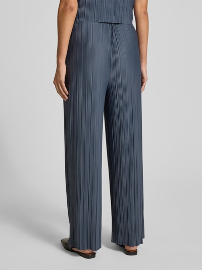 Frauenmodel trägt Wide Fit Stoffhose in Plissee-Optik Modell 'Uma' von Samsøe Samsøe, Elastischer-Material-Mix, Ganzkörperansicht Rückansicht.