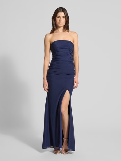 Kobiece modelka nosi Regular Fit Abendkleid mit Gehschlitz von Luxuar, półprzezroczysty materiał, krój regular fit, rozporek, taliowany, z odkrytymi ramionami, plisy, wszyty zamek błyskawiczny, halka pod spódnicę, długość tyłu w rozmiarze 36: 132 cm, szerokość w rozmiarze 36: 38 cm, granatowy kolor, gładka faktura. Ganzkörperansicht z przodu.