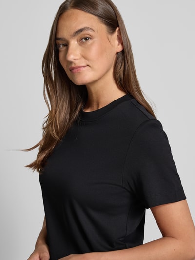 Frauenmodel trägt Boxy Fit T-Shirt aus reiner Baumwolle von s.Oliver RED LABEL in Unifarbe Schwarz, Nahaufnahme Oberkörper.